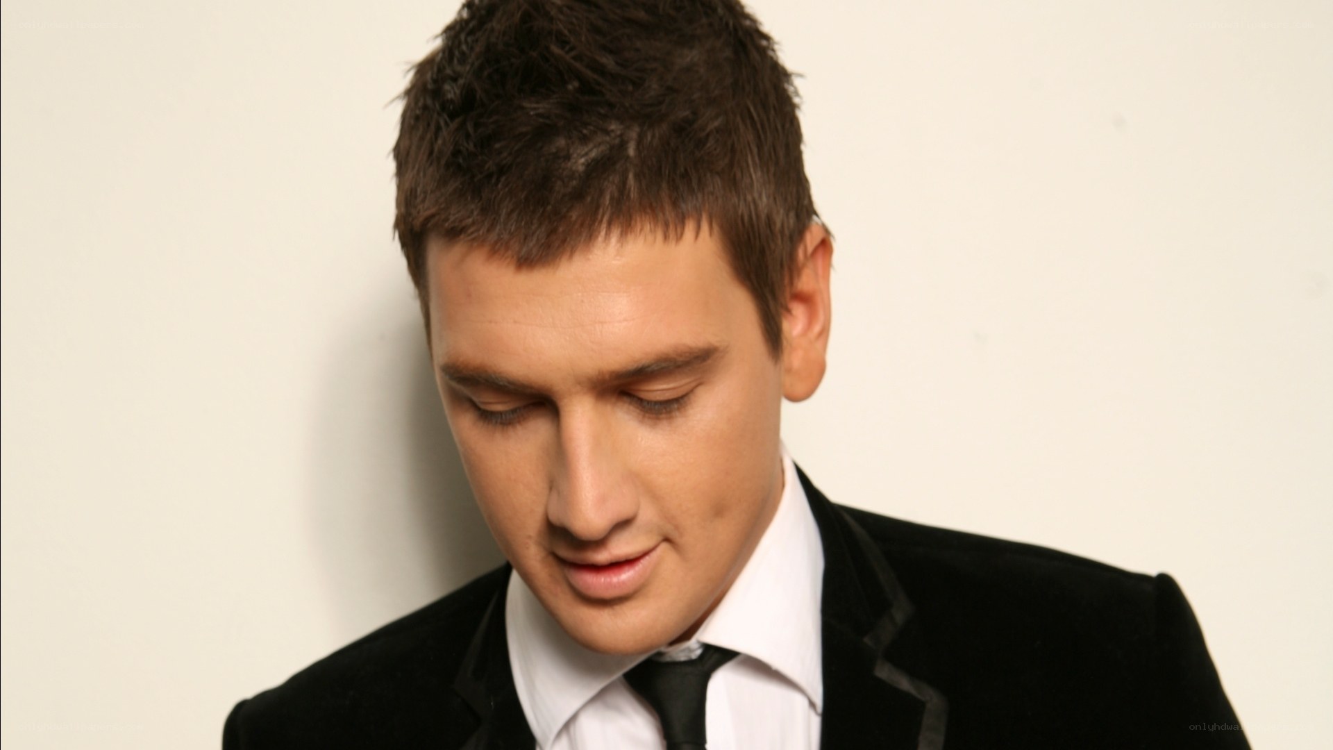 man in black suit looking down