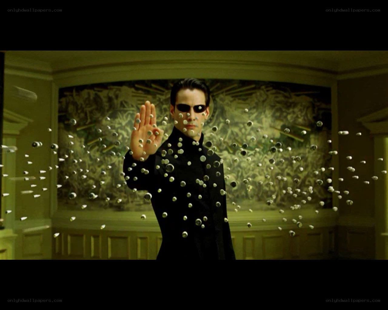 man in black suit stopping bullets