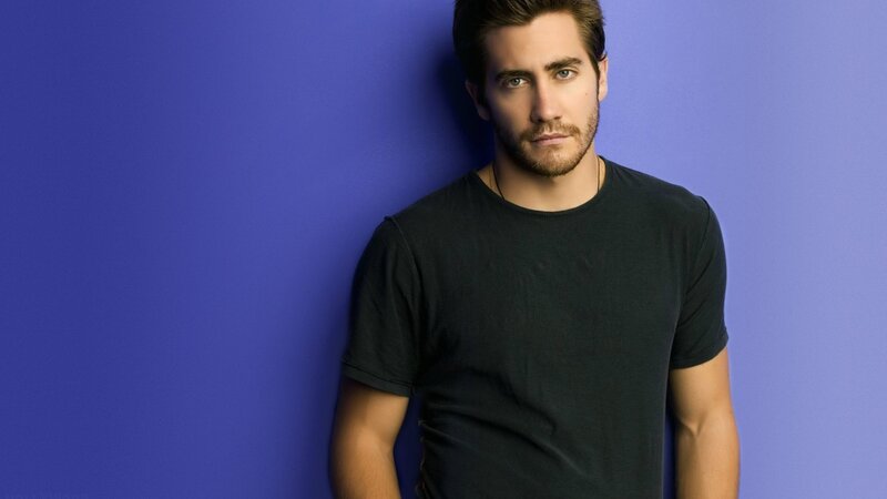 man in black t-shirt against blue wall