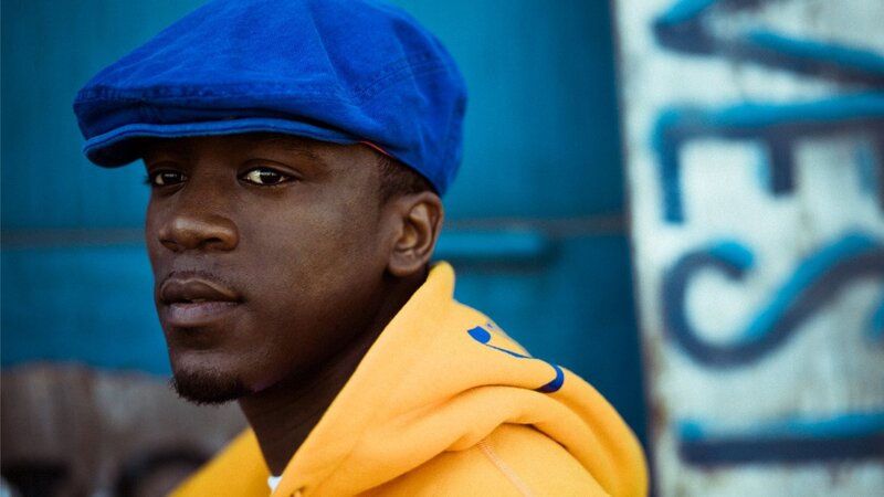 man in blue cap and yellow hoodie
