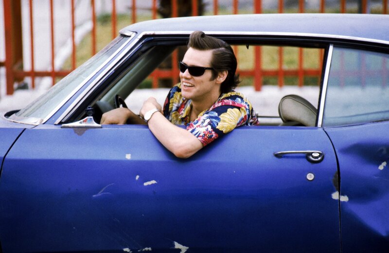 Man in blue car with floral shirt