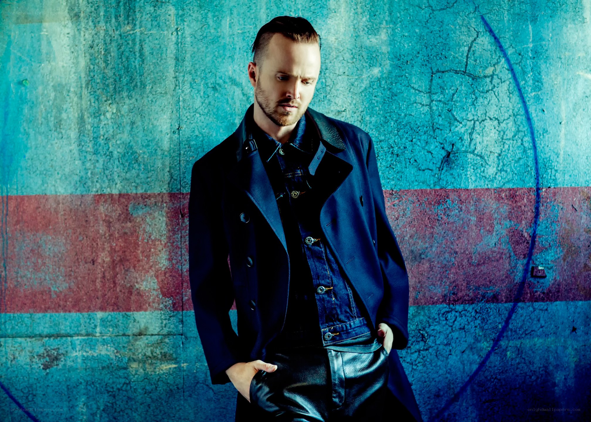 man in blue coat against wall
