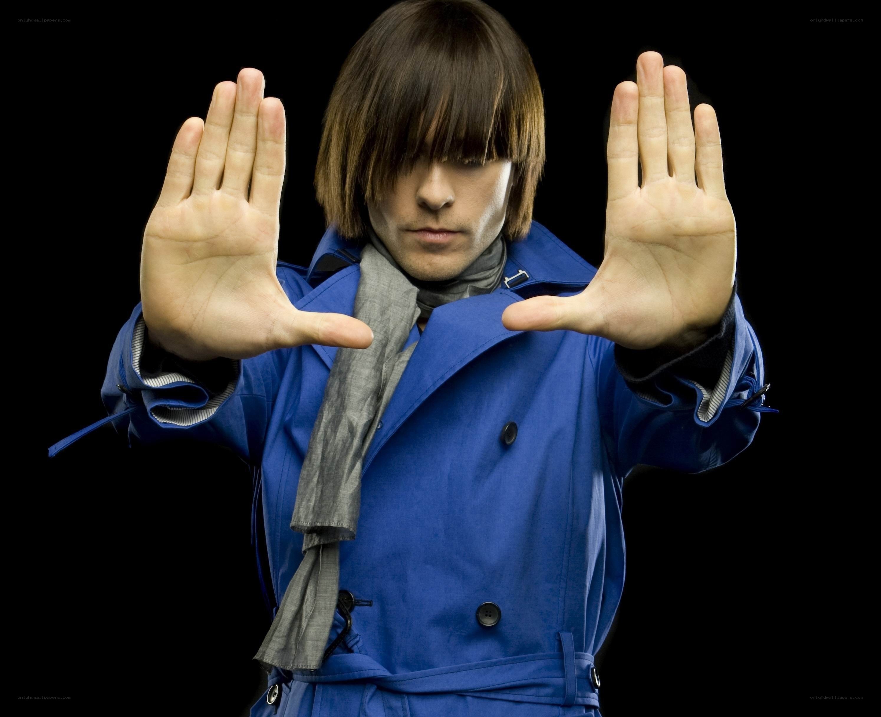man in blue coat with hands up