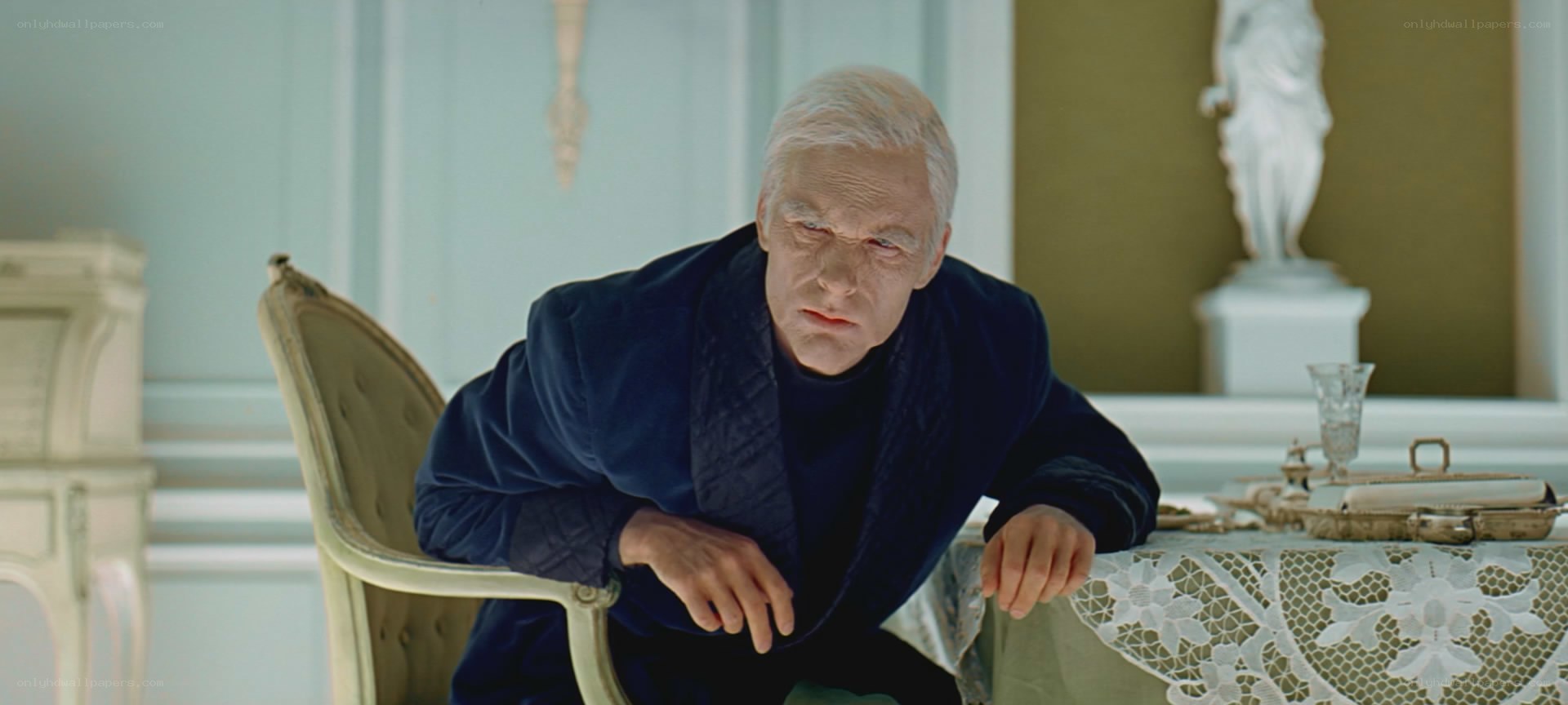 man in blue robe at table