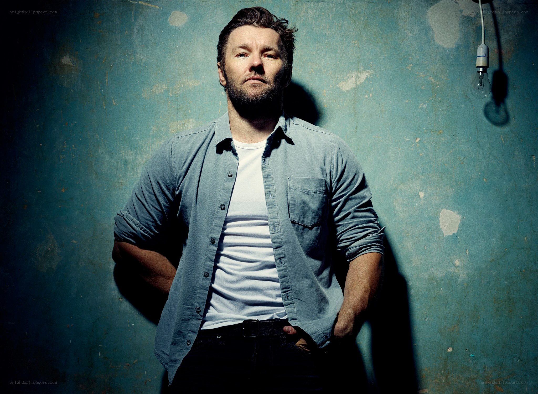 man in blue shirt against wall