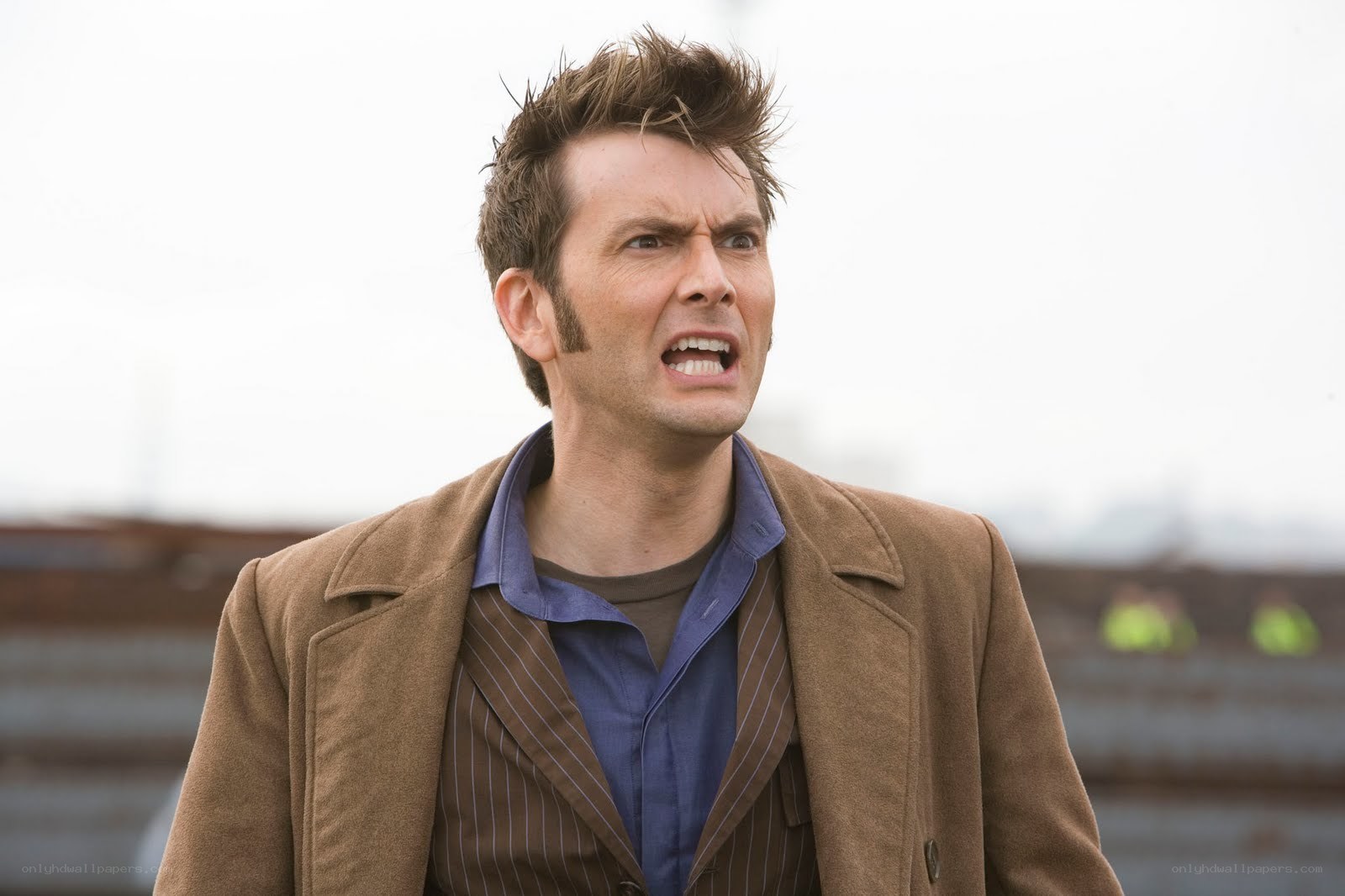 man in brown coat looking angry