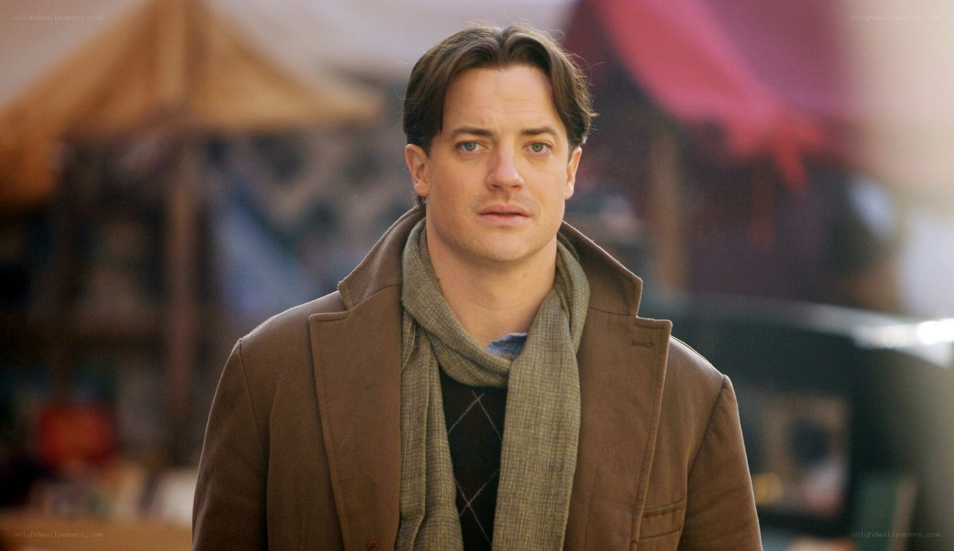 man in brown coat looking serious