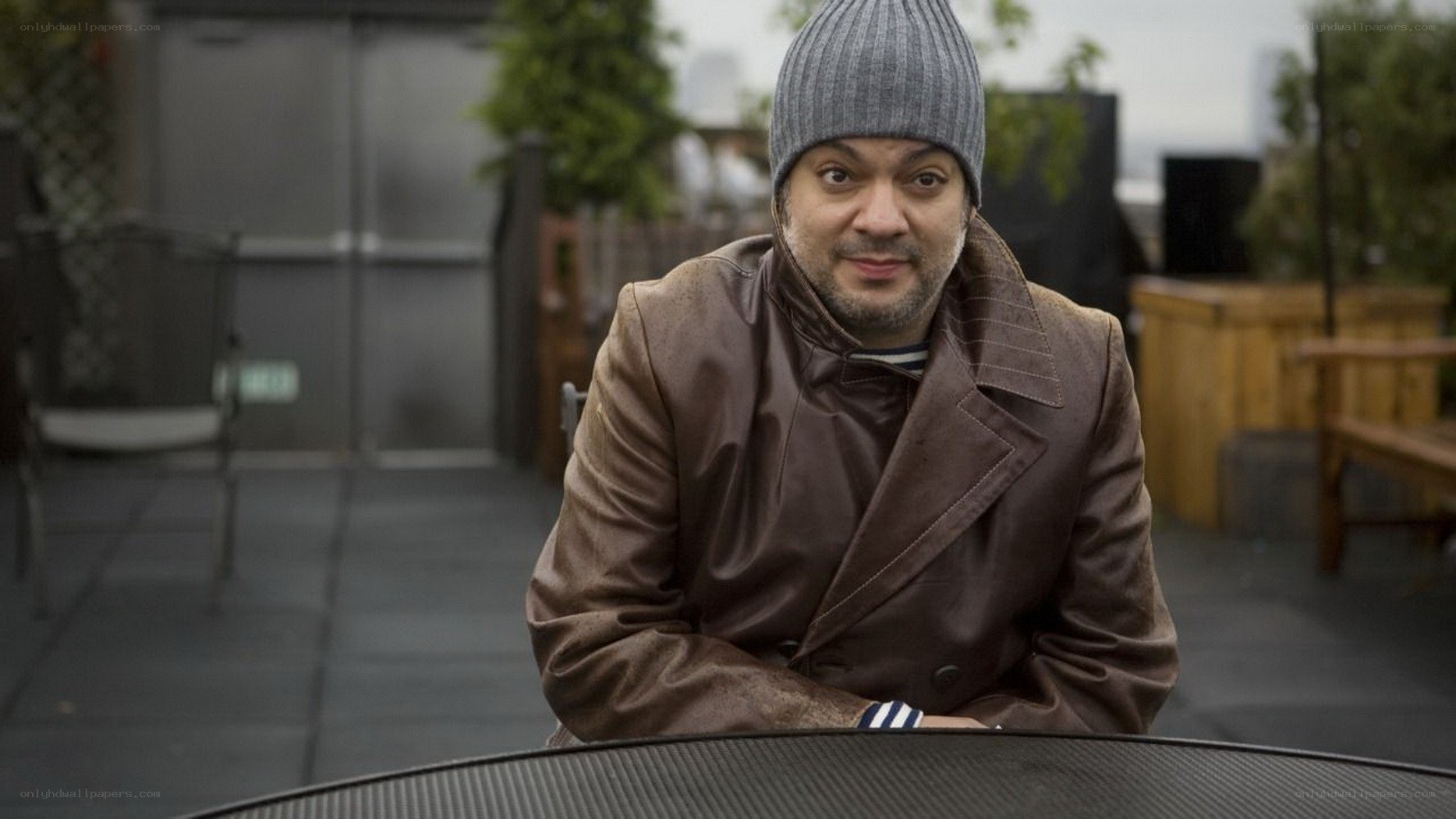 man in brown coat on rooftop