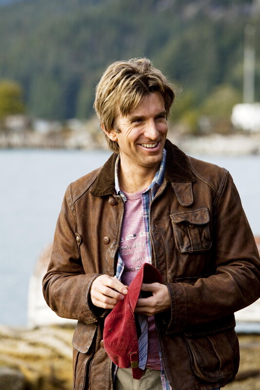 man in brown jacket smiling