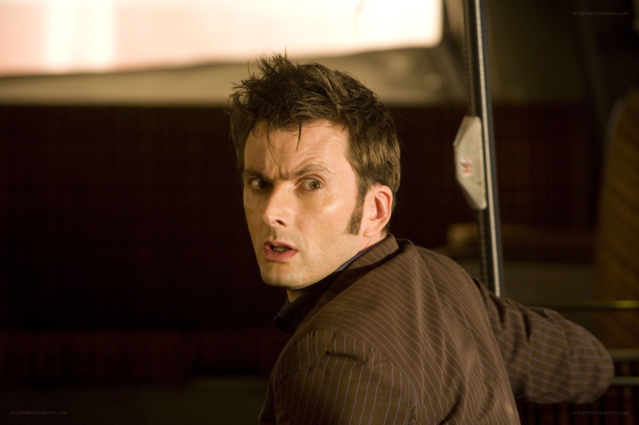 man in brown suit looking back