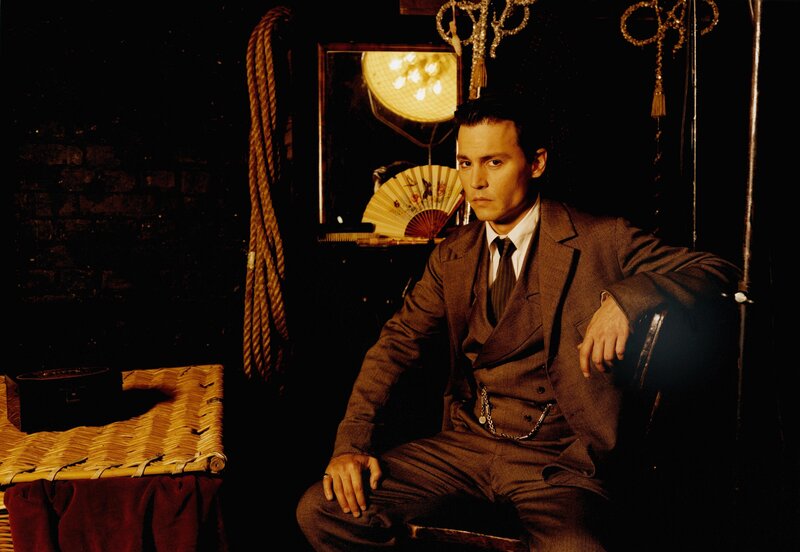 man in brown suit sitting