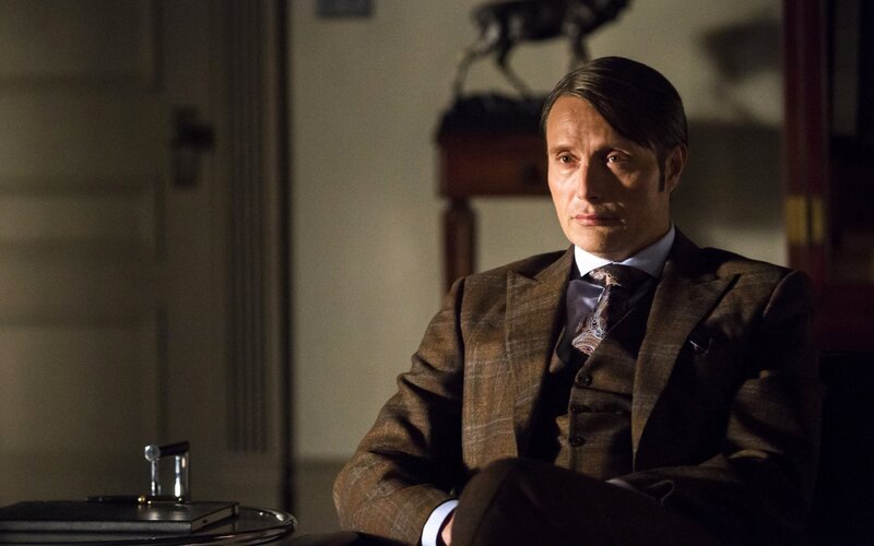 man in brown suit sitting