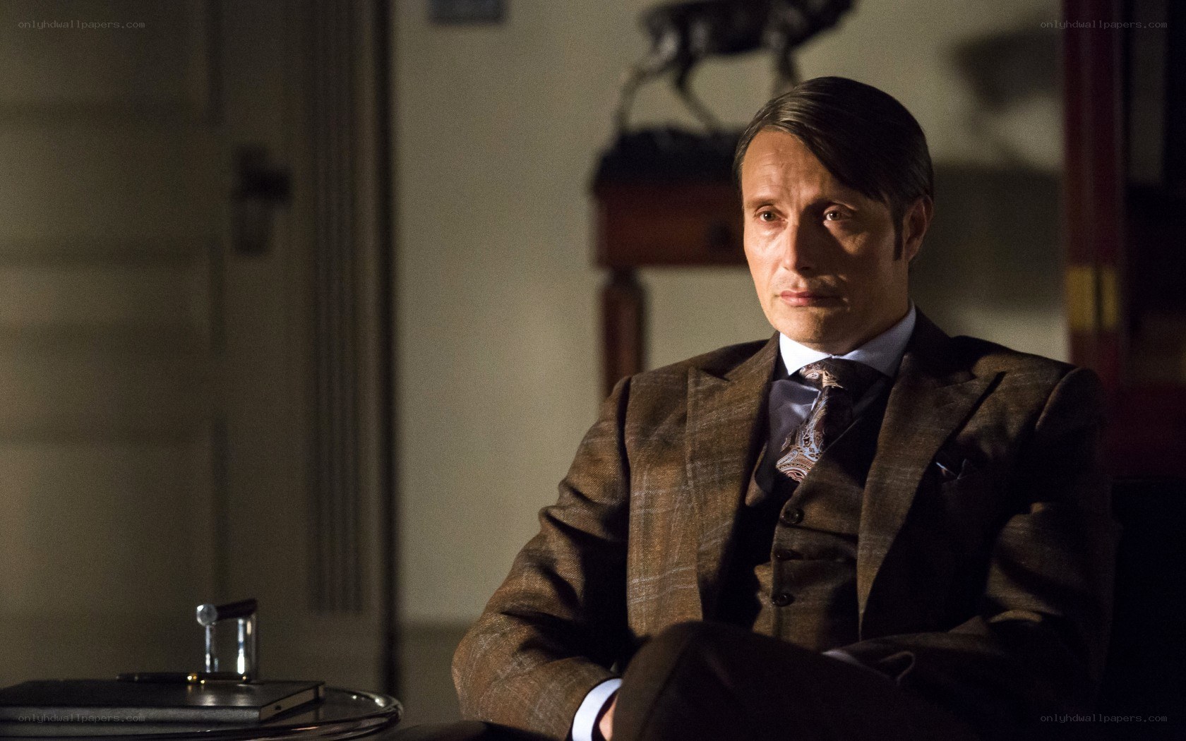 man in brown suit sitting