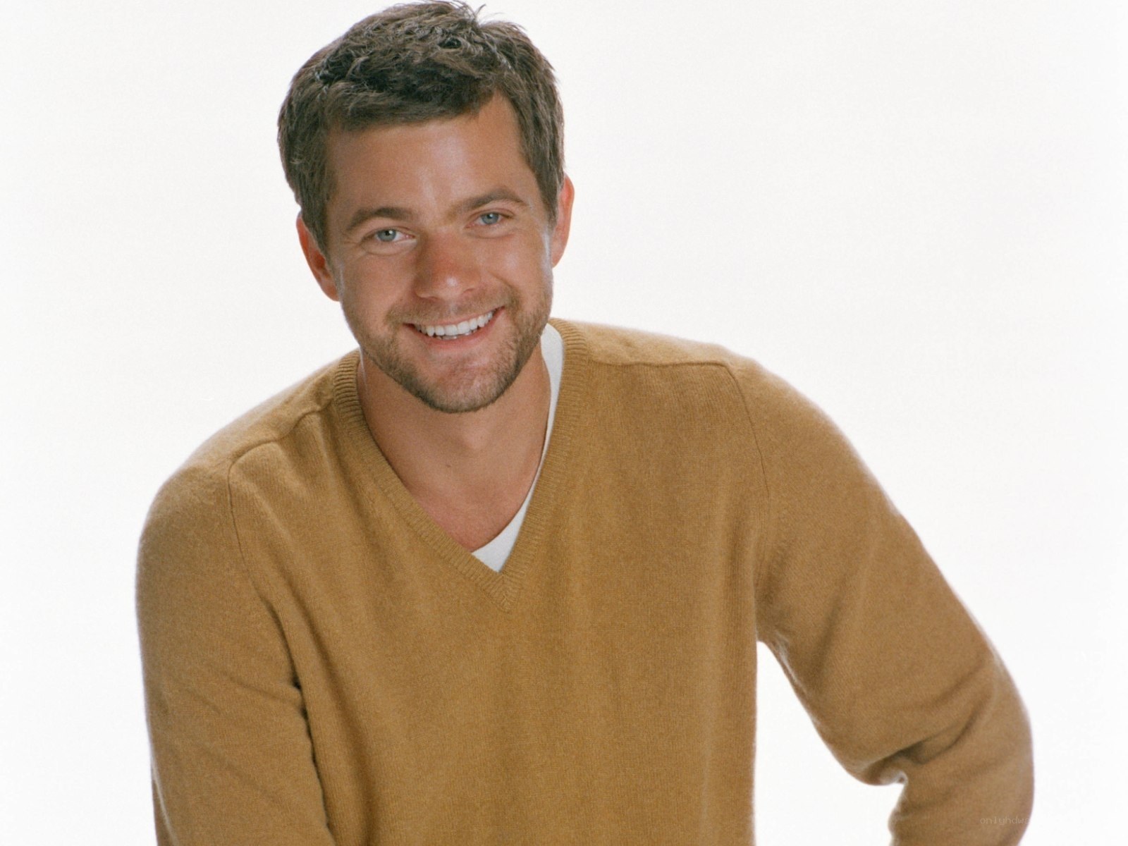 man in brown sweater smiling