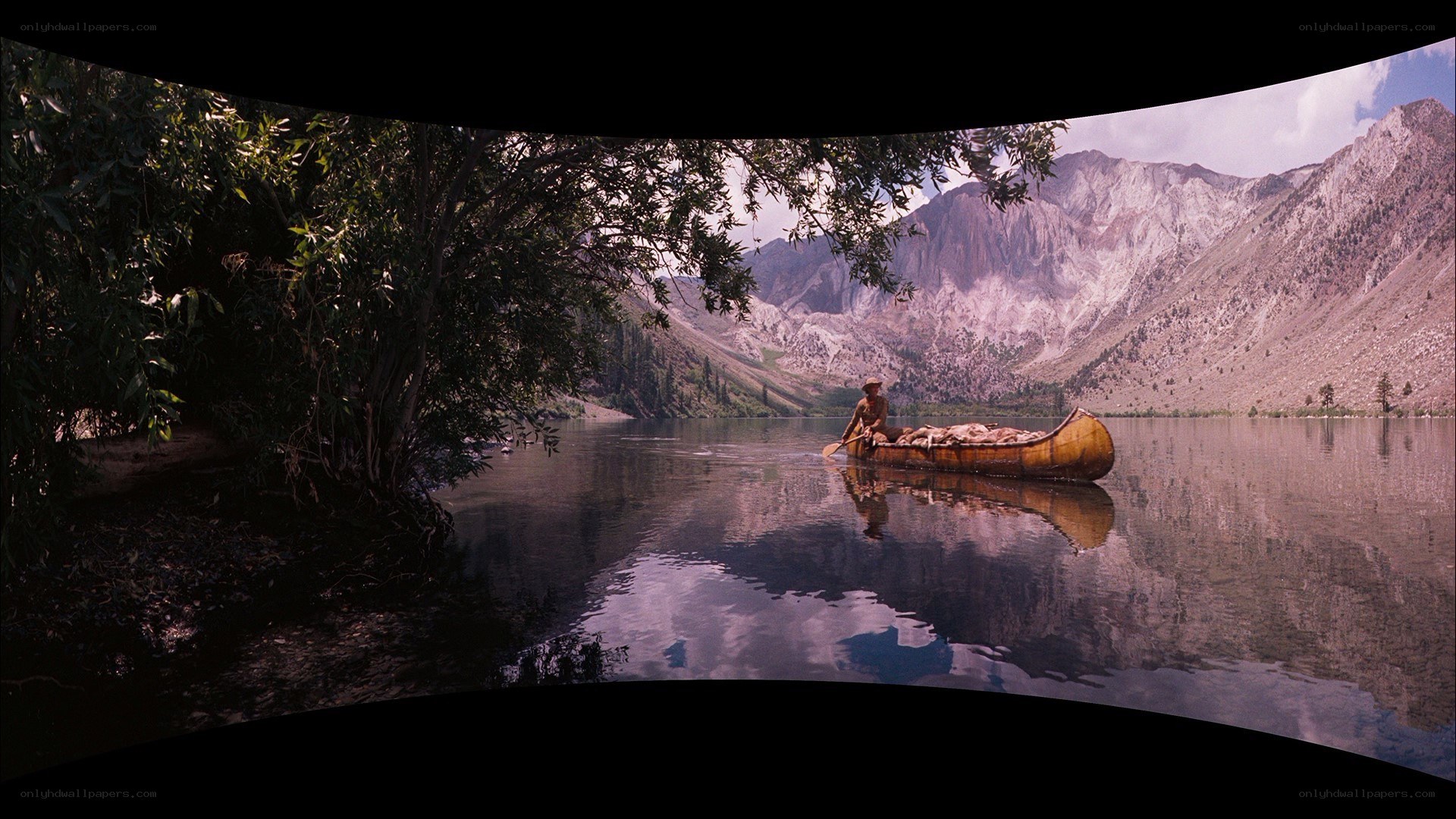 Man in canoe on mountain lake