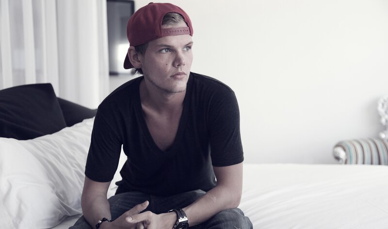 man in cap sitting on bed
