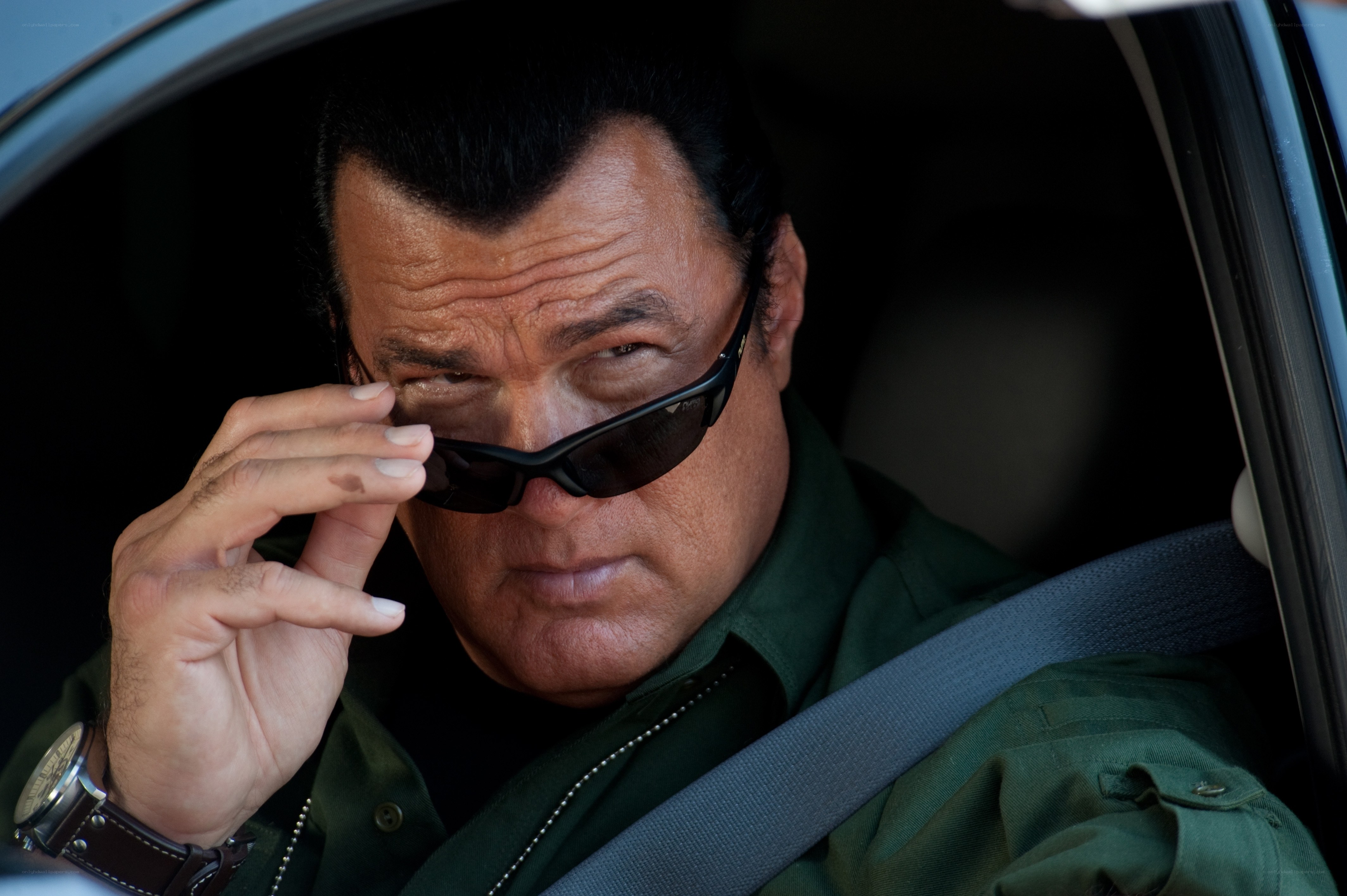 man in car adjusting sunglasses