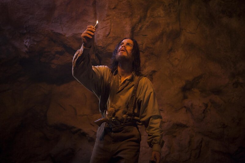 man in cave with match