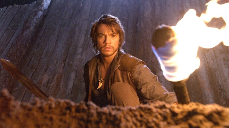 man in cave with torch