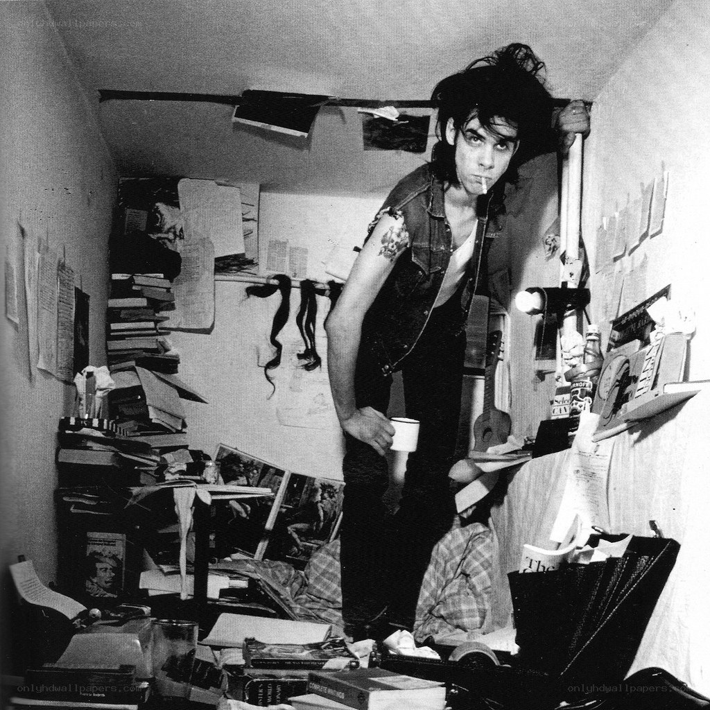 Man in cluttered room with cigarette