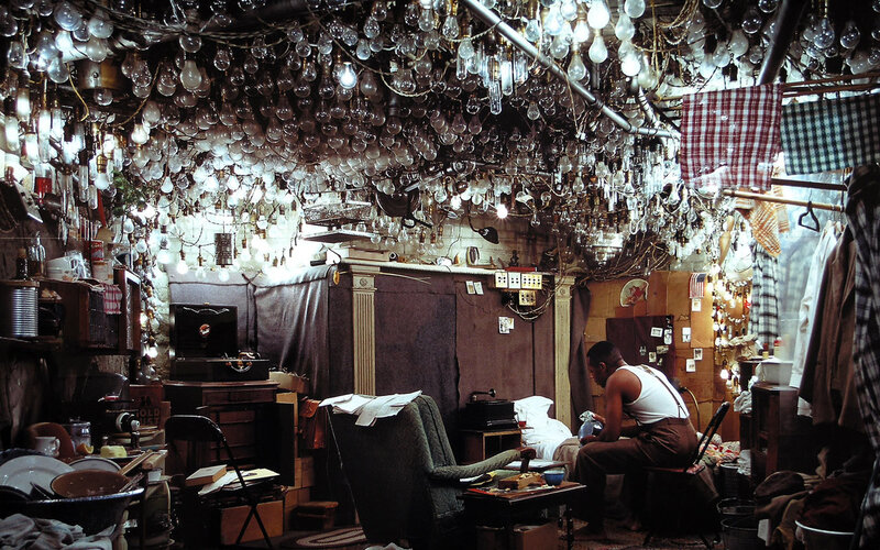 Man in cluttered room with light bulbs