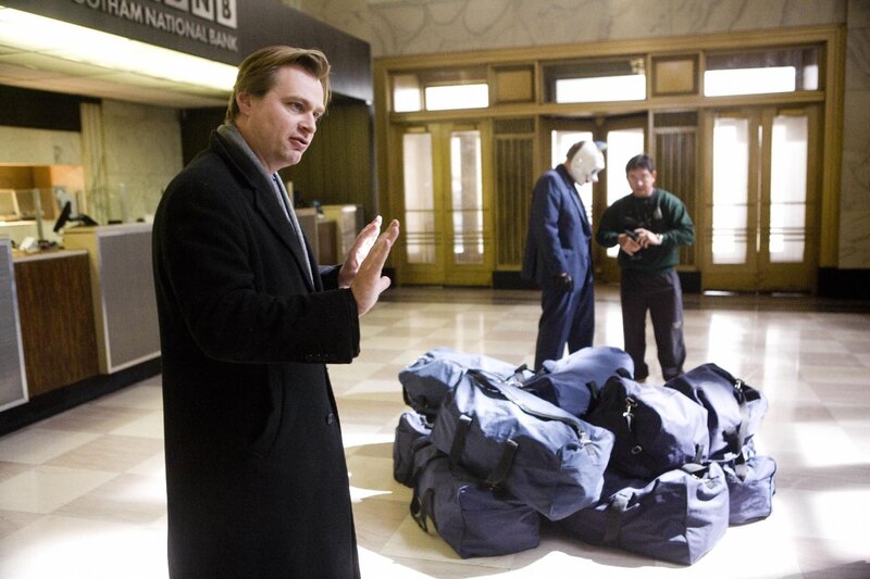 Man in coat at bank with bags