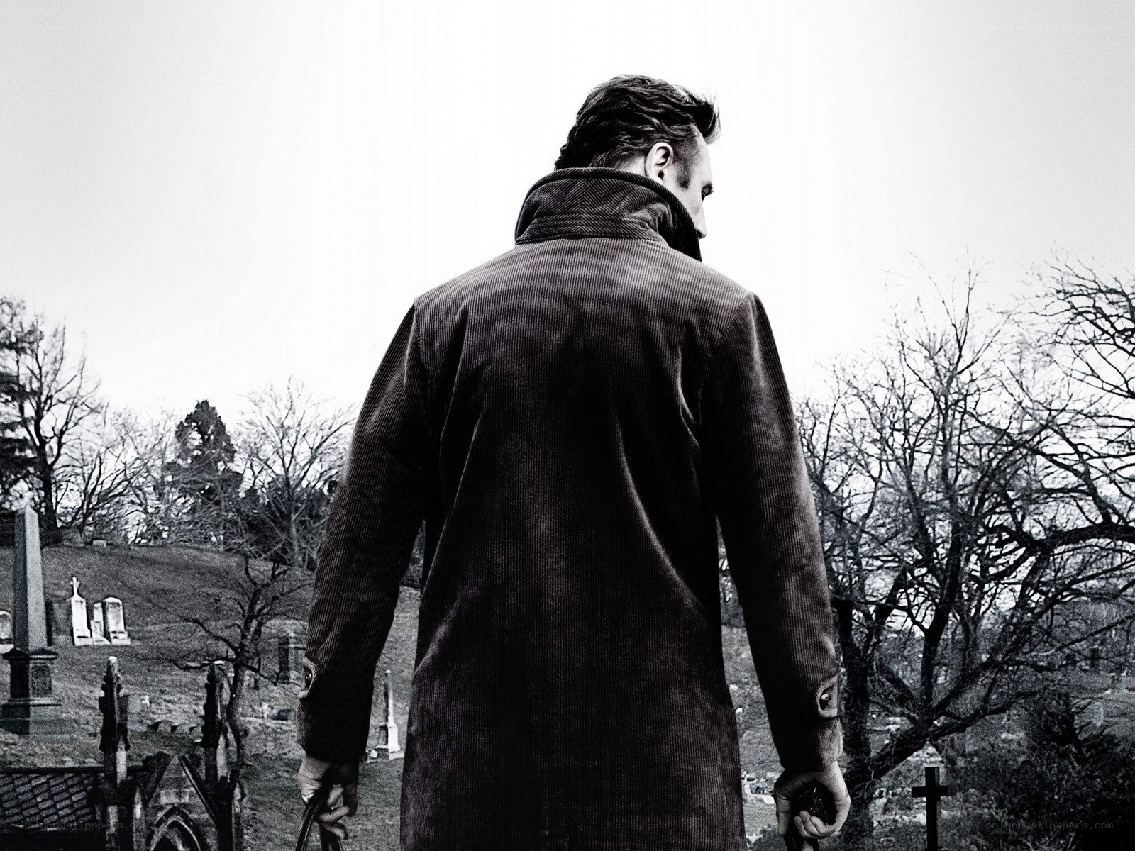 man in coat at cemetery