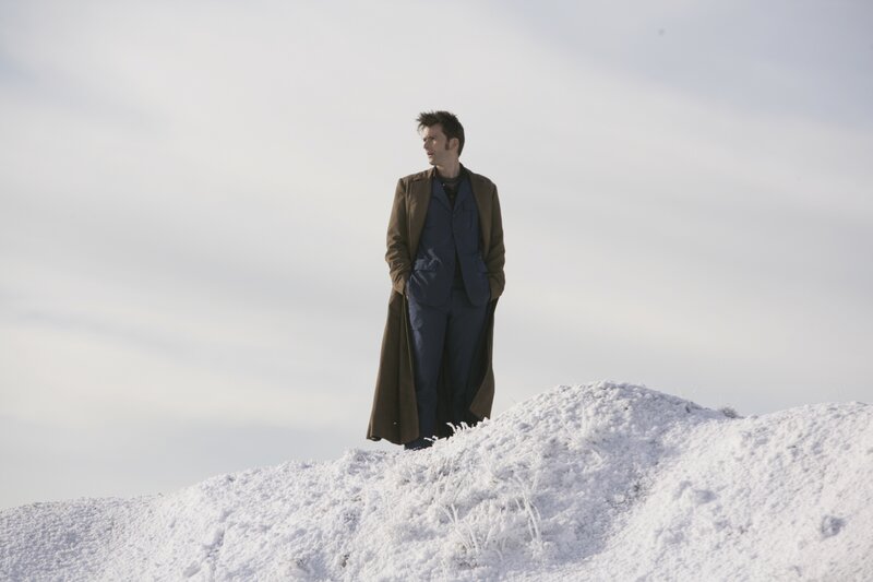 man in coat on snowy hill