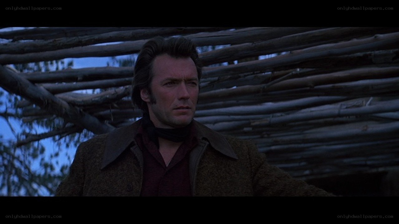 man in coat under wooden structure