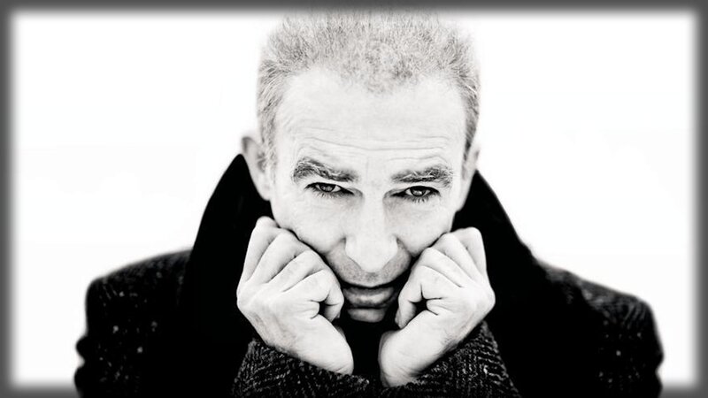 man in coat with hands on face