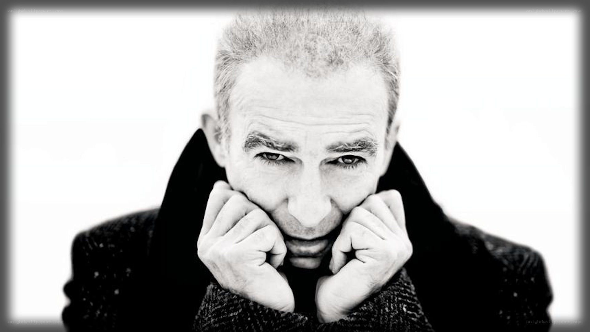 man in coat with hands on face