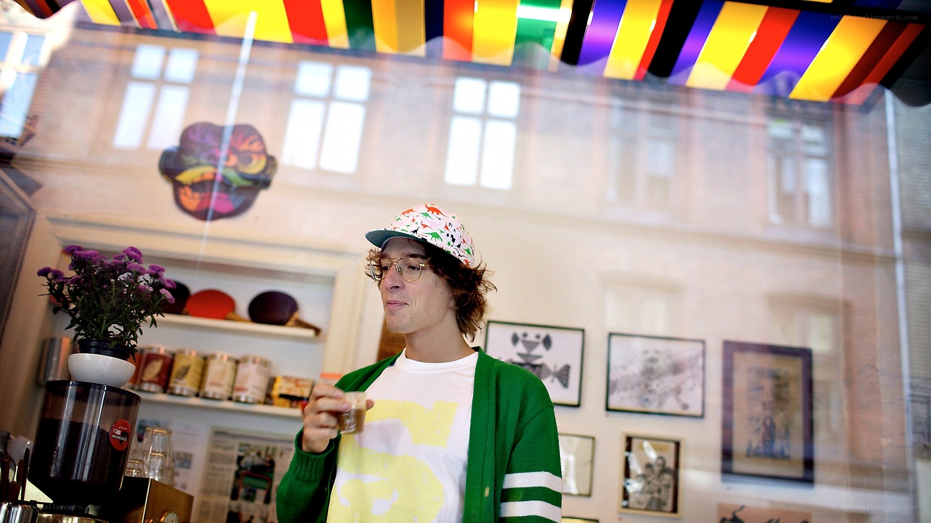 Man in colorful hat holding coffee