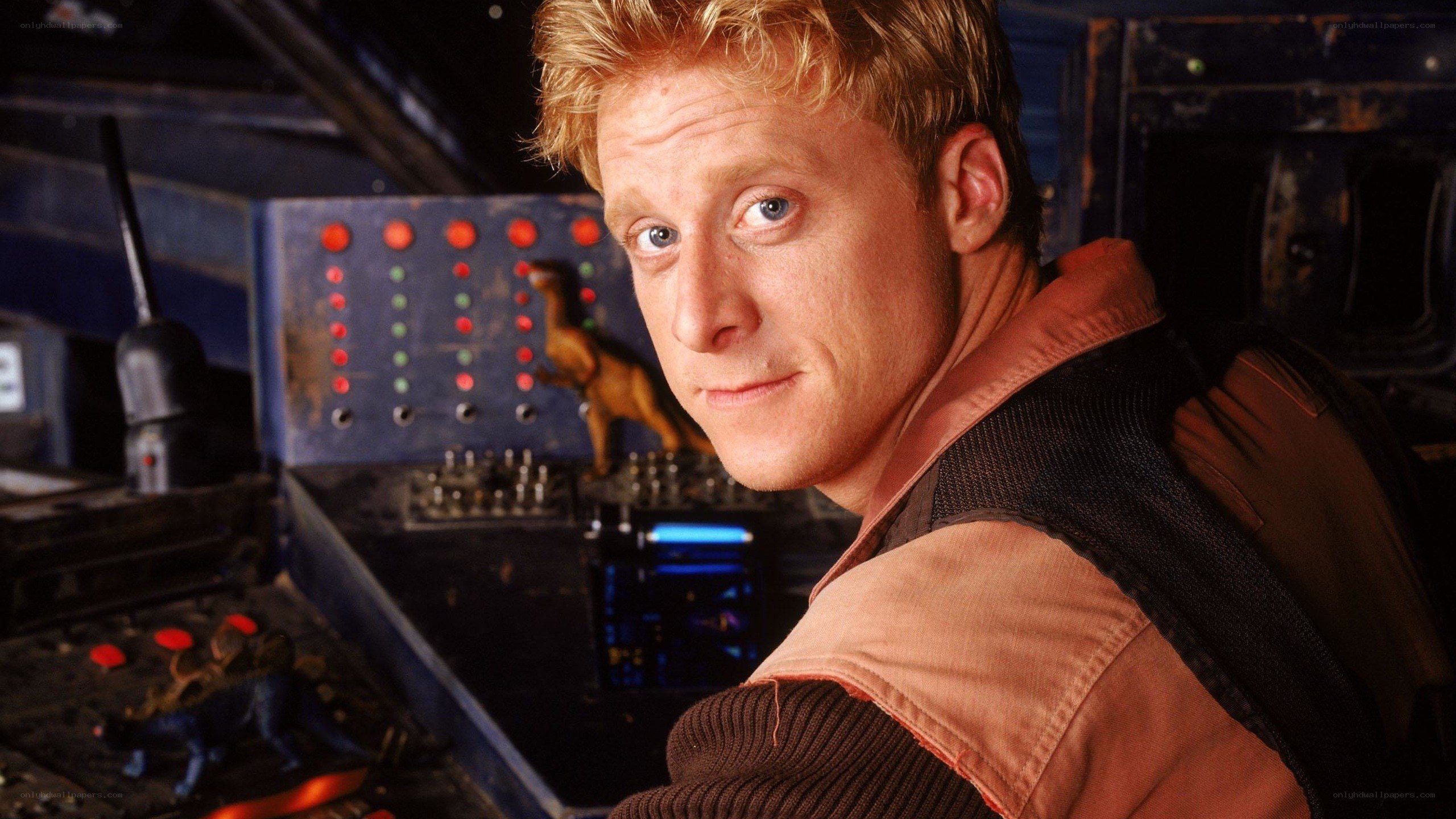 man in control room with dinosaur figurines