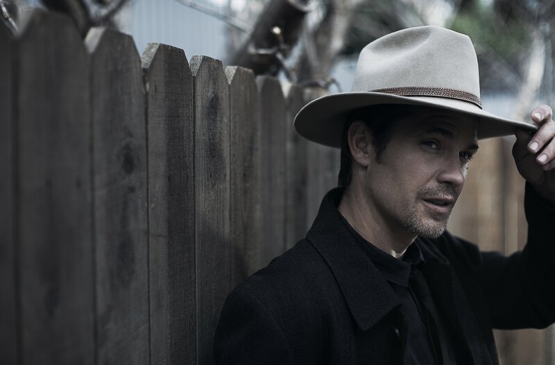 man in cowboy hat by fence