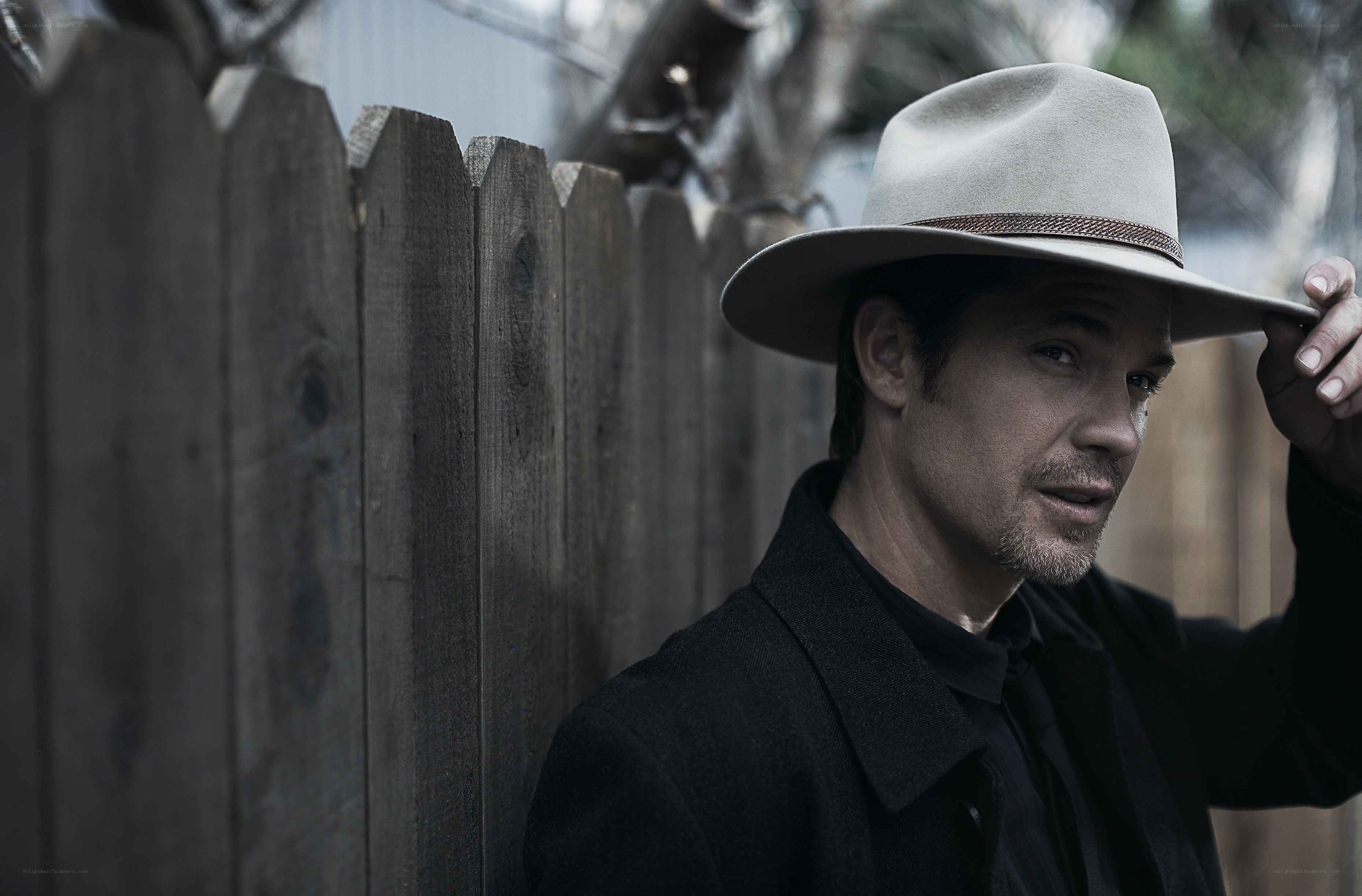 man in cowboy hat by fence