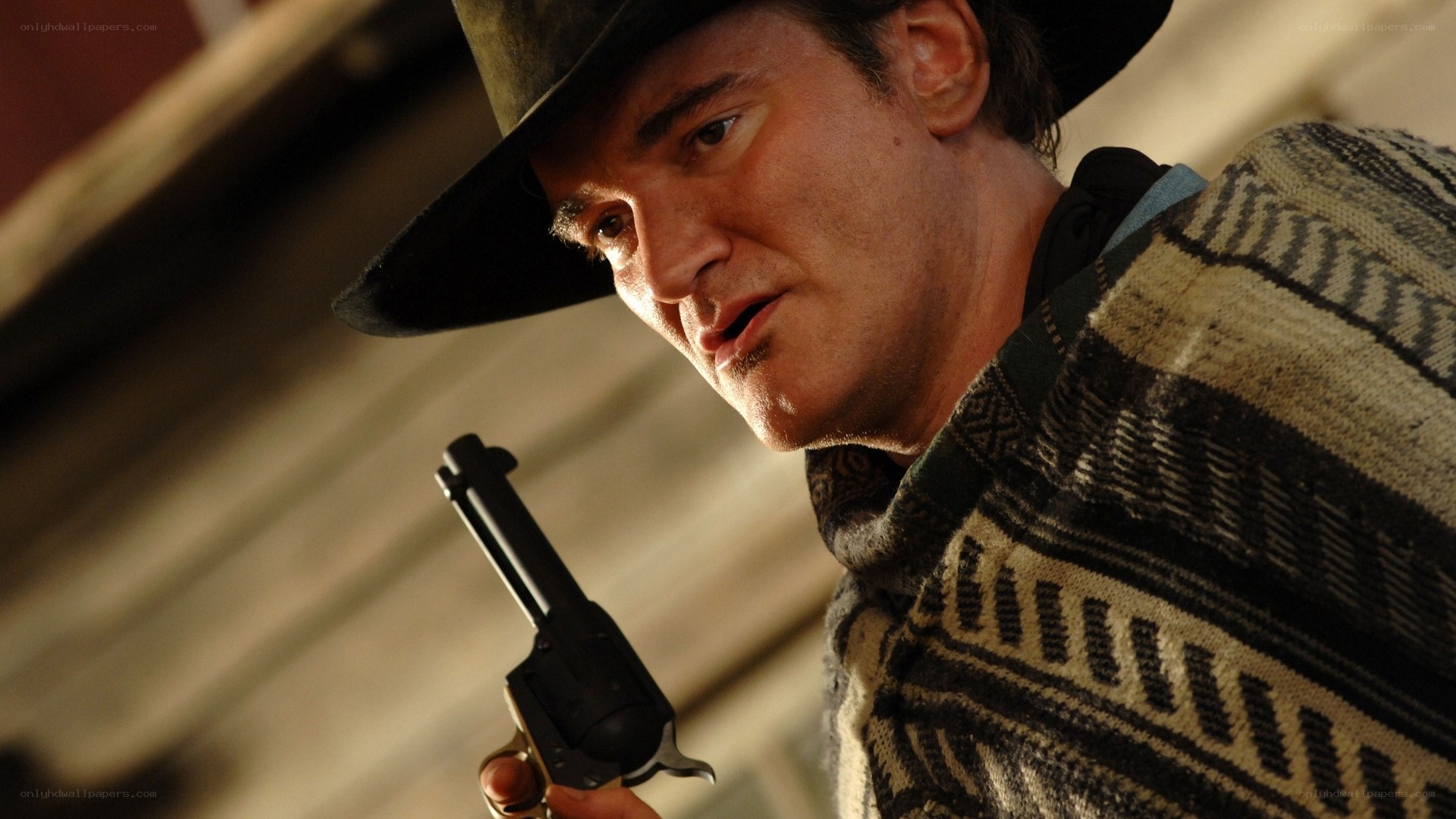 man in cowboy hat holding gun