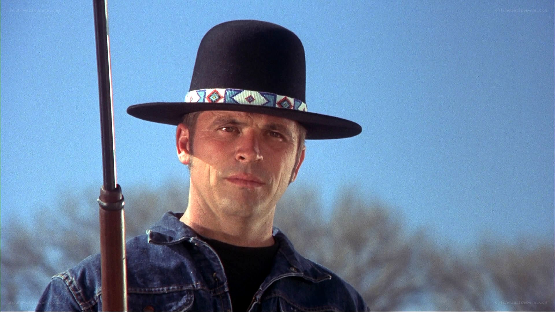 man in cowboy hat holding rifle