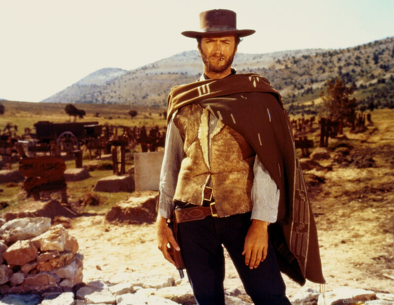 Man in cowboy hat stands in cemetery