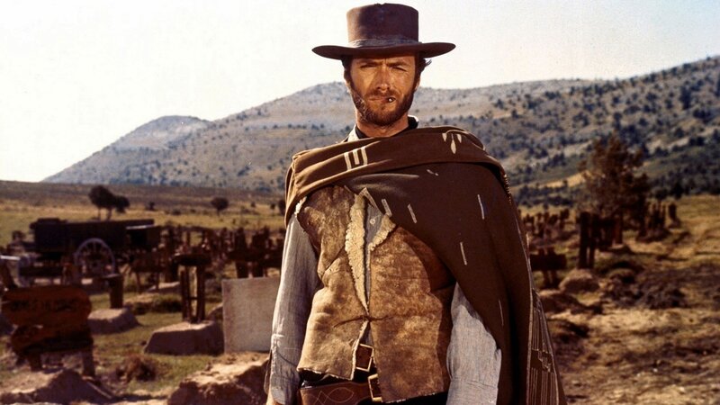 Man in cowboy hat stands in cemetery