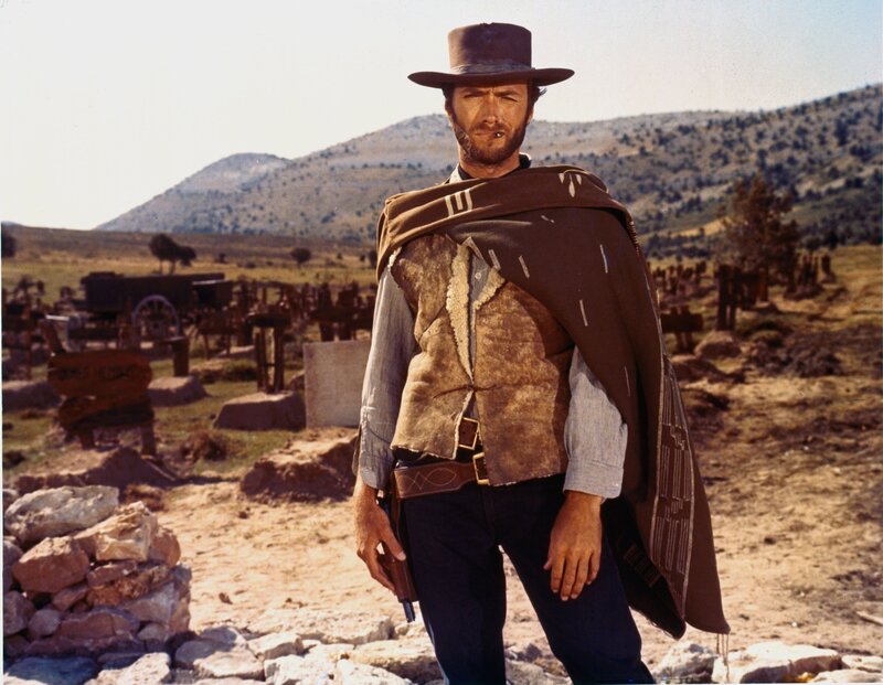 Man in cowboy hat stands in cemetery