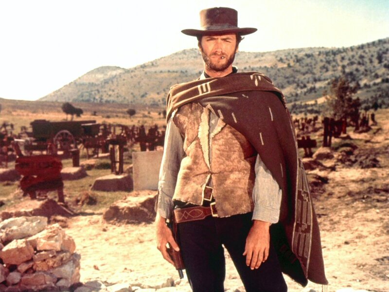 Man in cowboy hat stands in desert