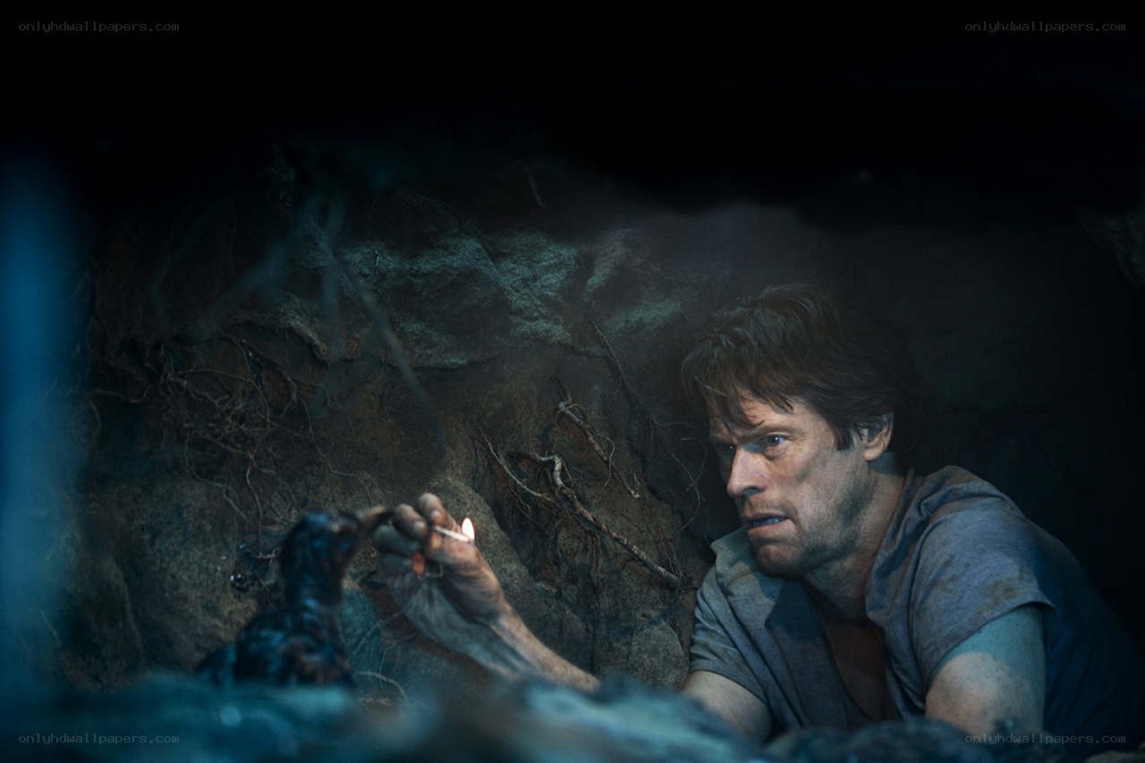 man in dark cave with match