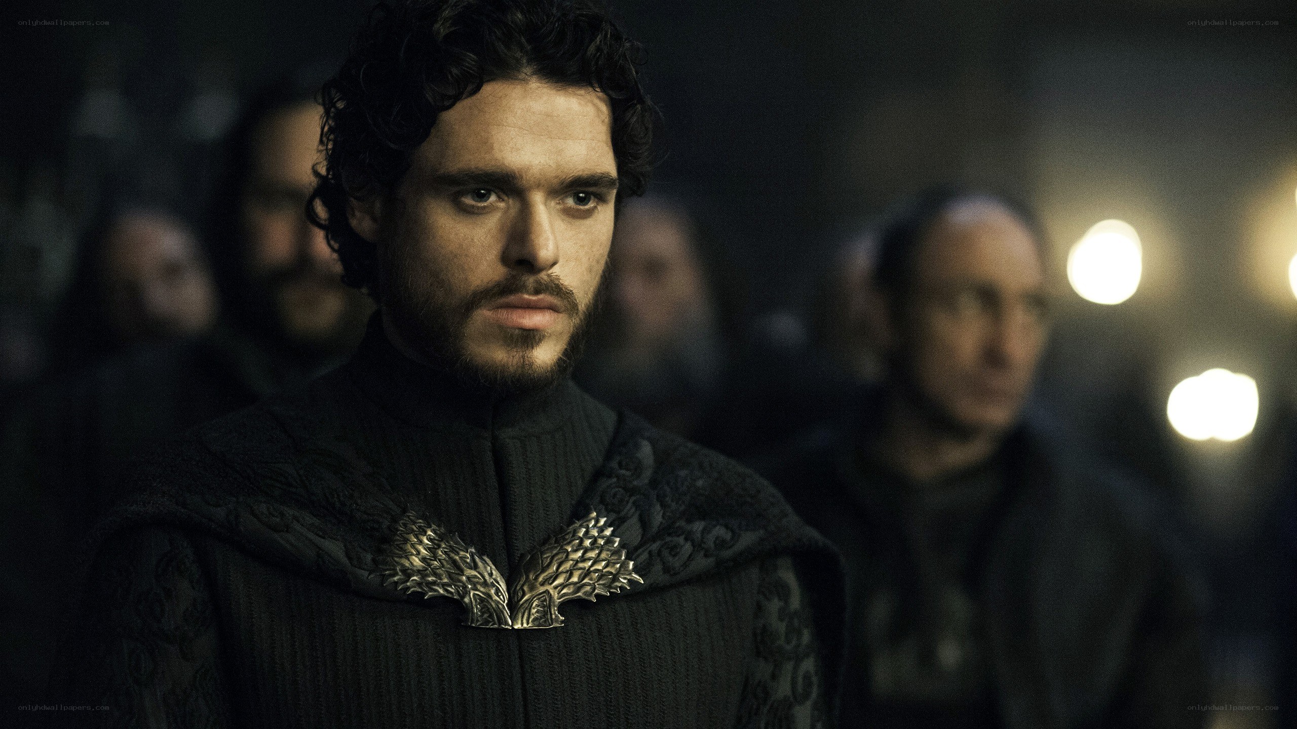 man in dark cloak with brooch