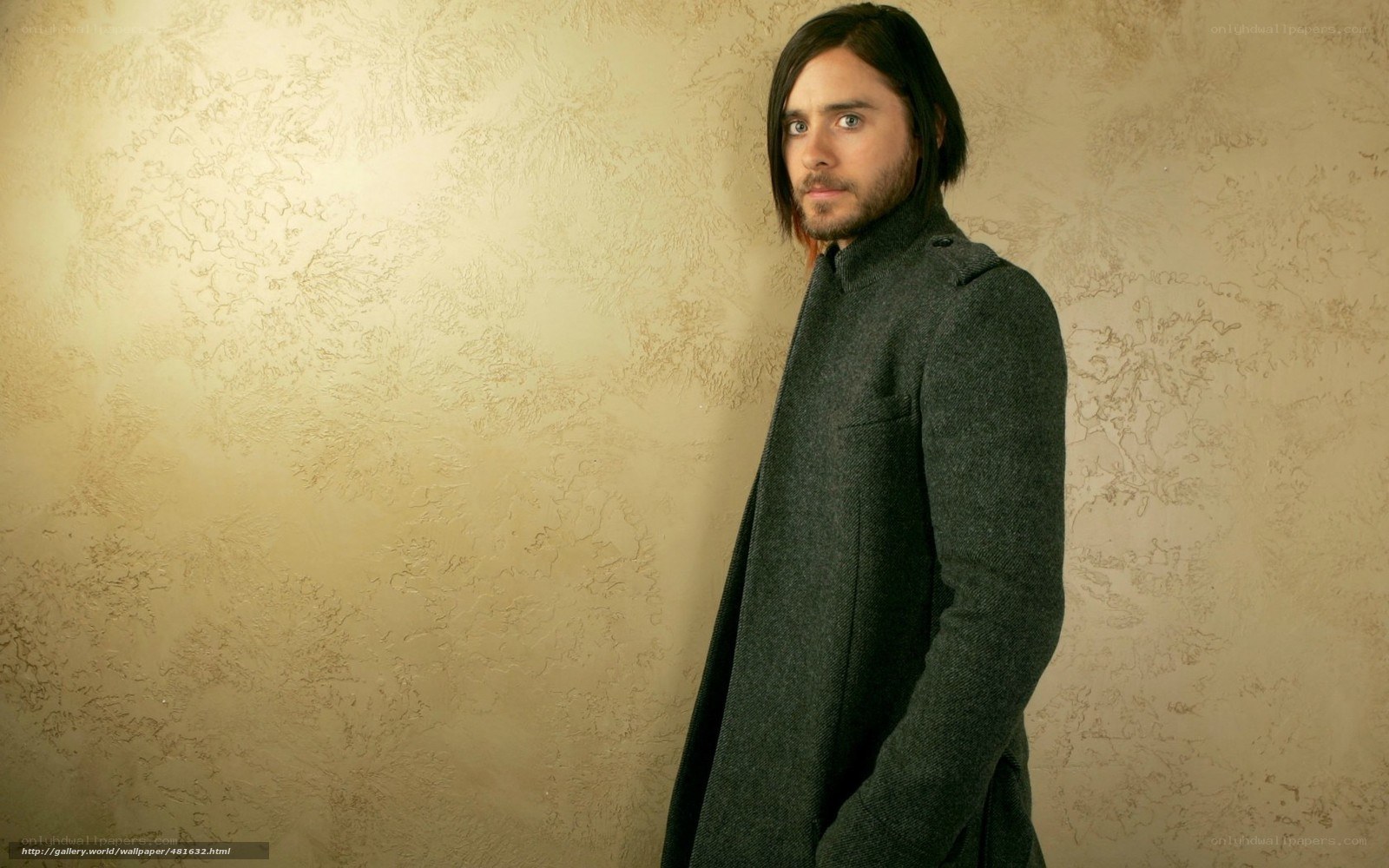 man in dark coat against textured wall