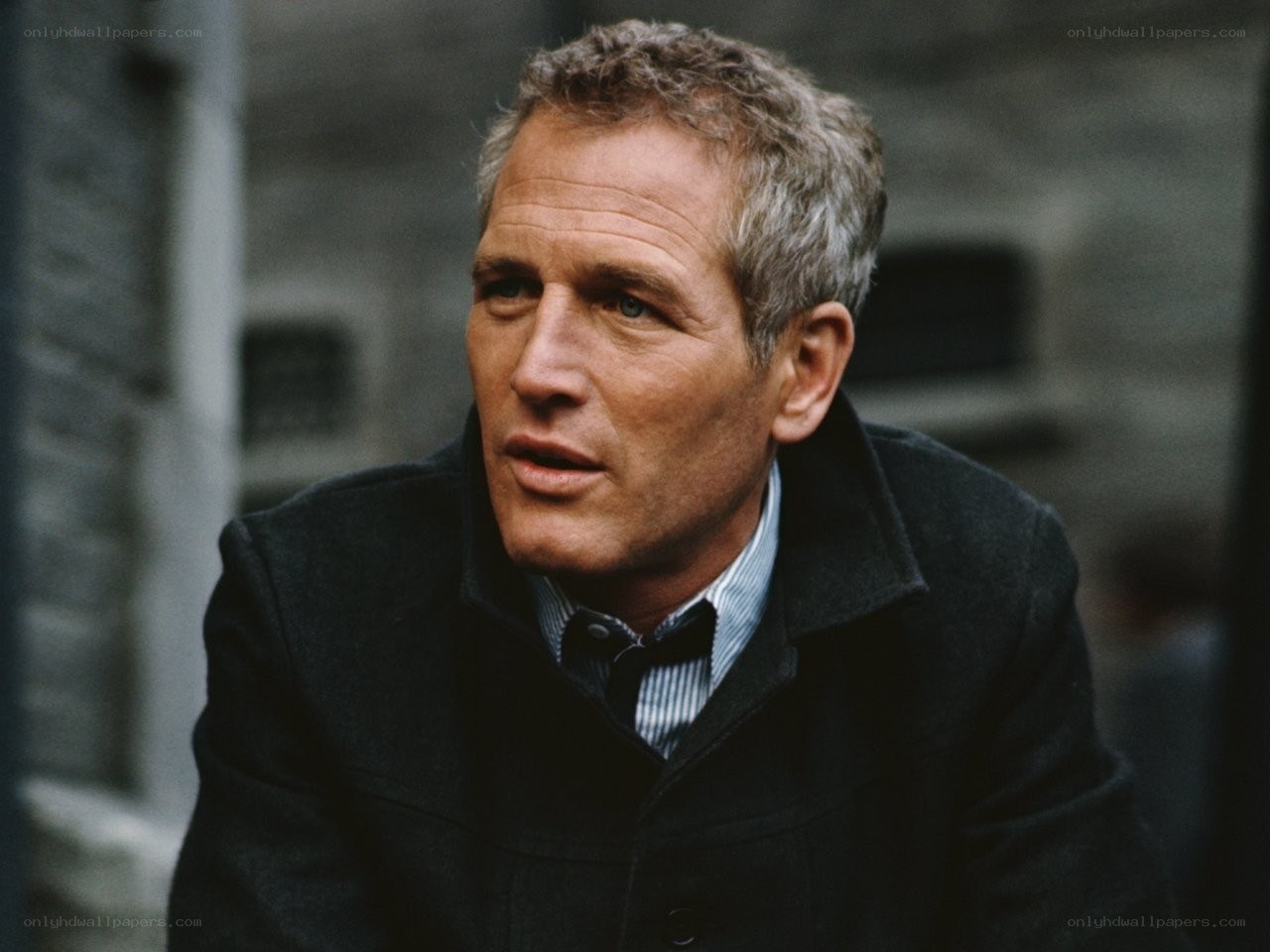 man in dark coat looking away