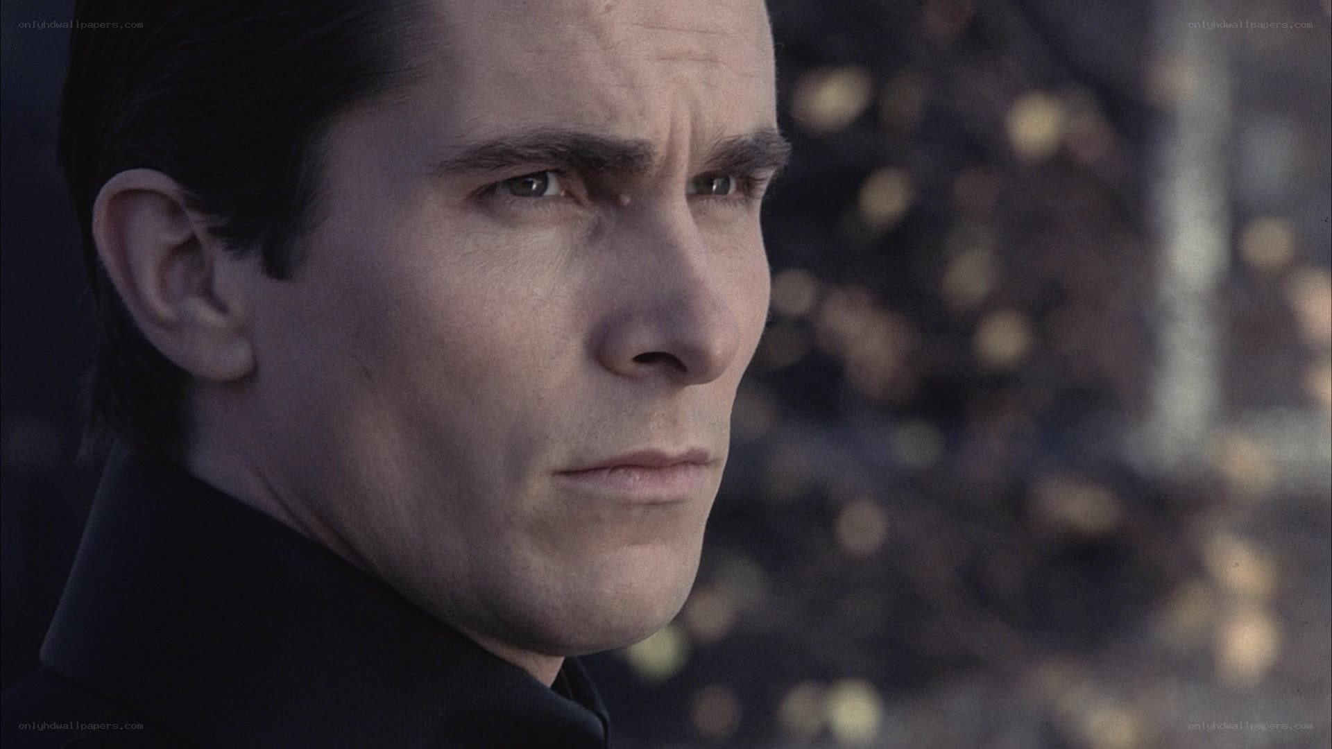man in dark coat looking away