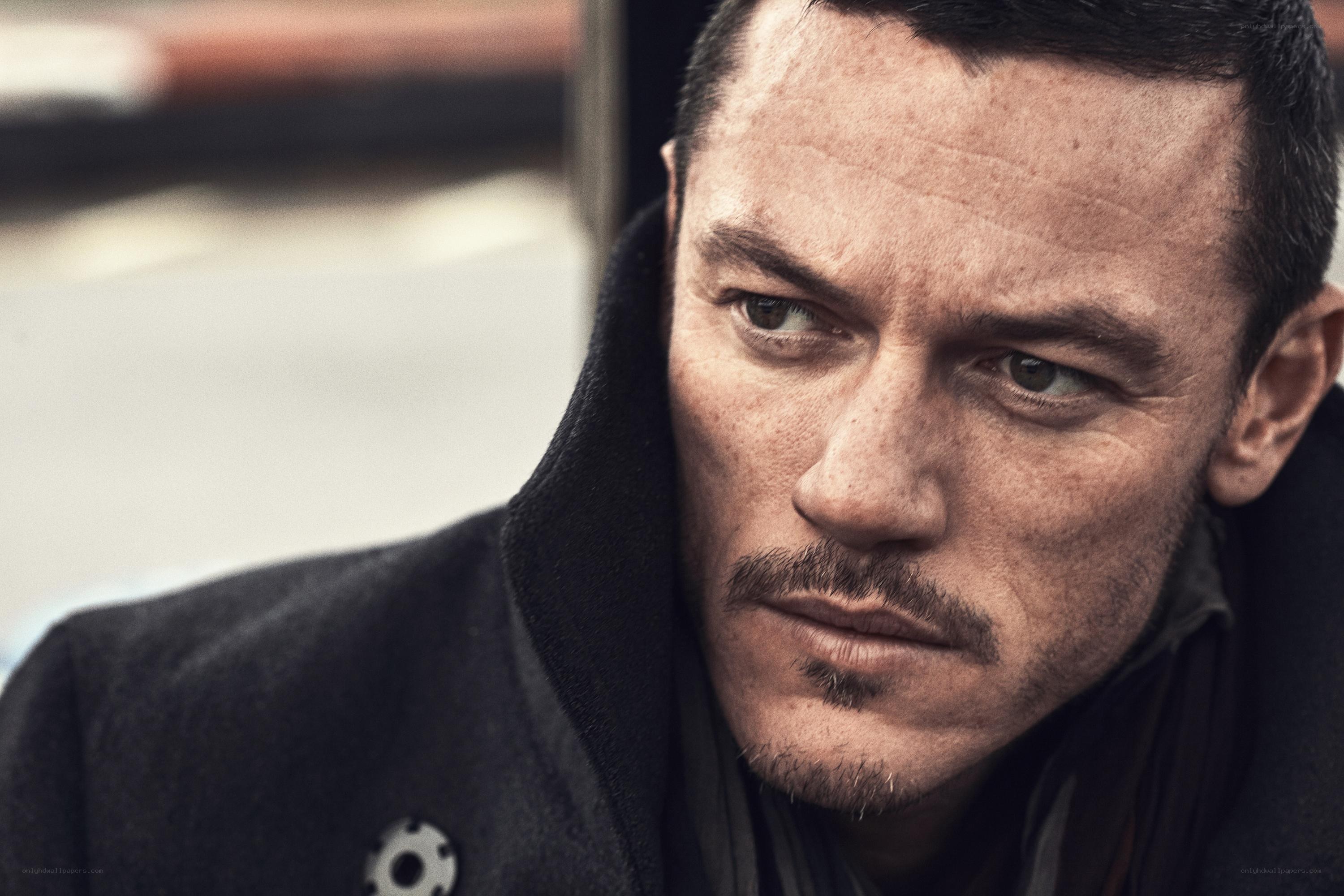 man in dark coat looking serious