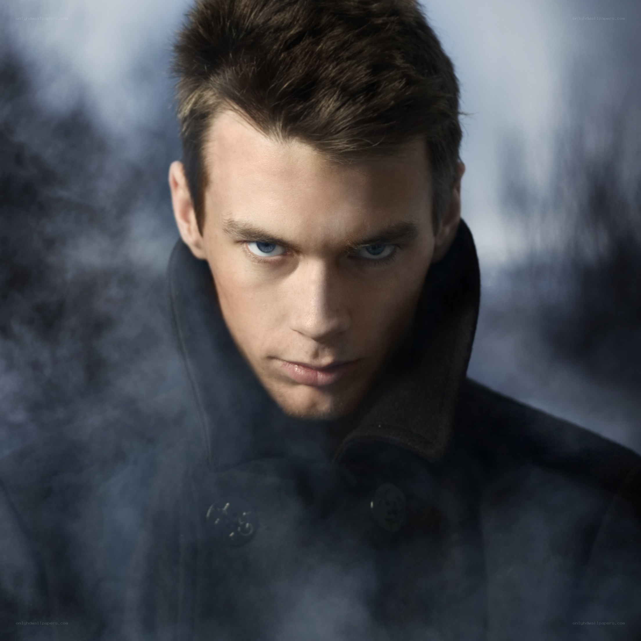 man in dark coat with smoke