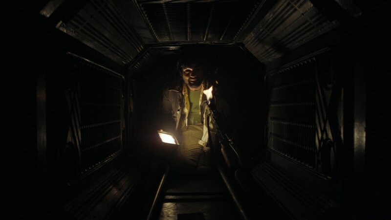 man in dark corridor with flashlight