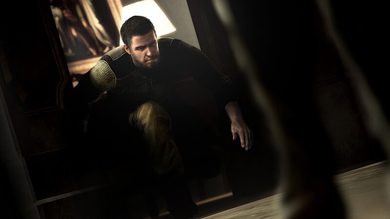 man in dark room crouching